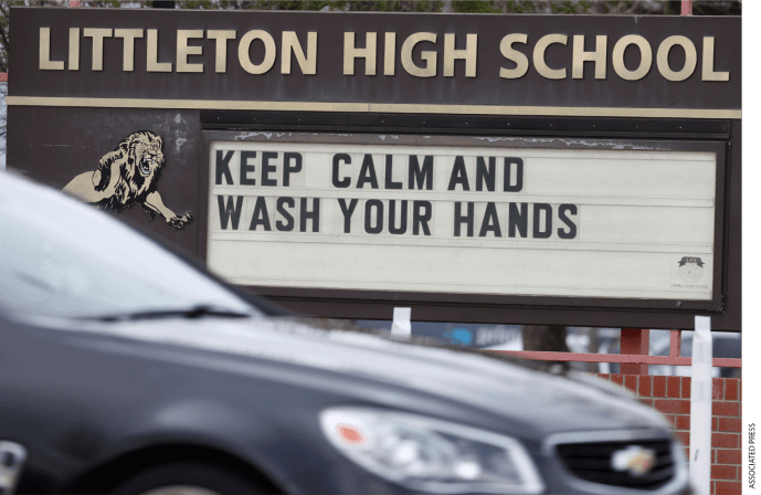 A sign offers advice in dealing with the new coronavirus, outside Littleton High School Sunday, April 26, 2020, in Littleton, Colo.