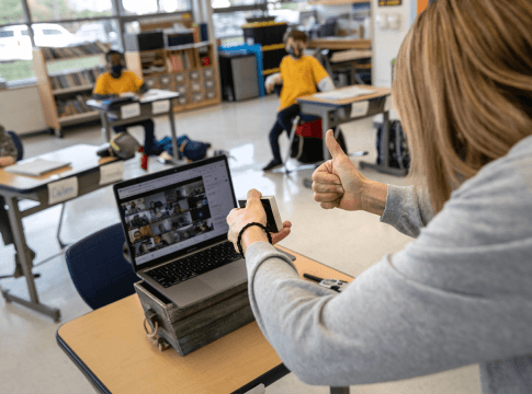 Third-grade teacher Cara Denison manages students in person and remotely, simultaneously, at Rogers International School in Stamford, Connecticut.