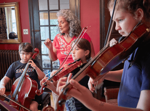 Caprice Corona assists her three children during a music lesson at home.