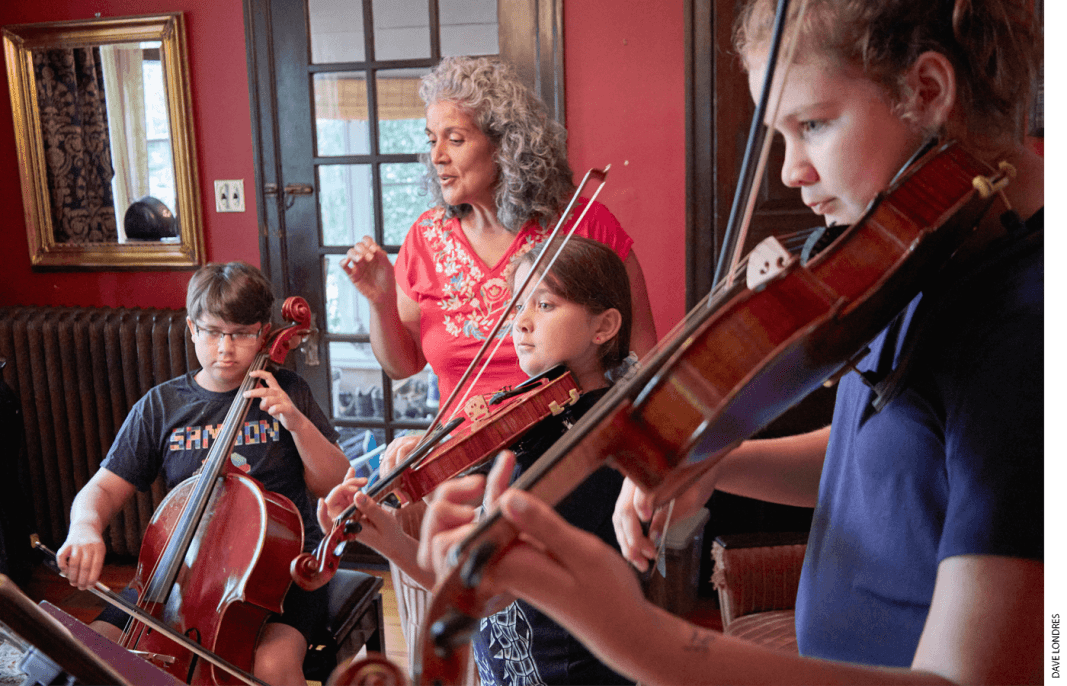 Caprice Corona assists her three children during a music lesson at home.