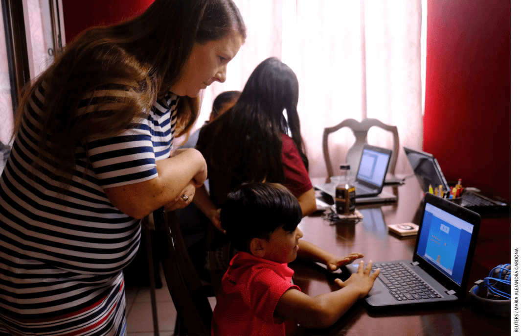 Jennifer Panditaratne of Broward County, Florida, works with her husband to help their children with home-schooling assignments throughout the day.
