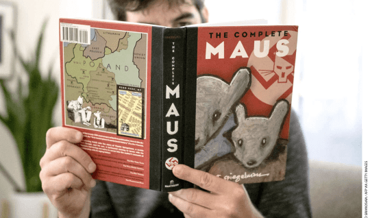 A man reads a copy of Maus by Art Spiegelman