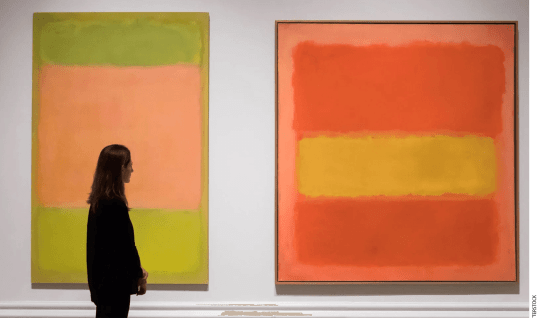 A person stands in front of two Mark Rothko paintings